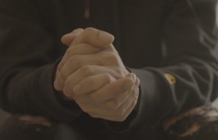 Single individual clasping their hands together