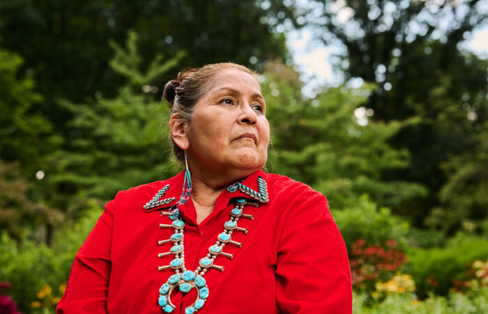 Headshot of Native American in traditional clothing and jewelry.