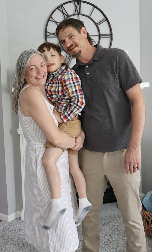 Family of three smiling.